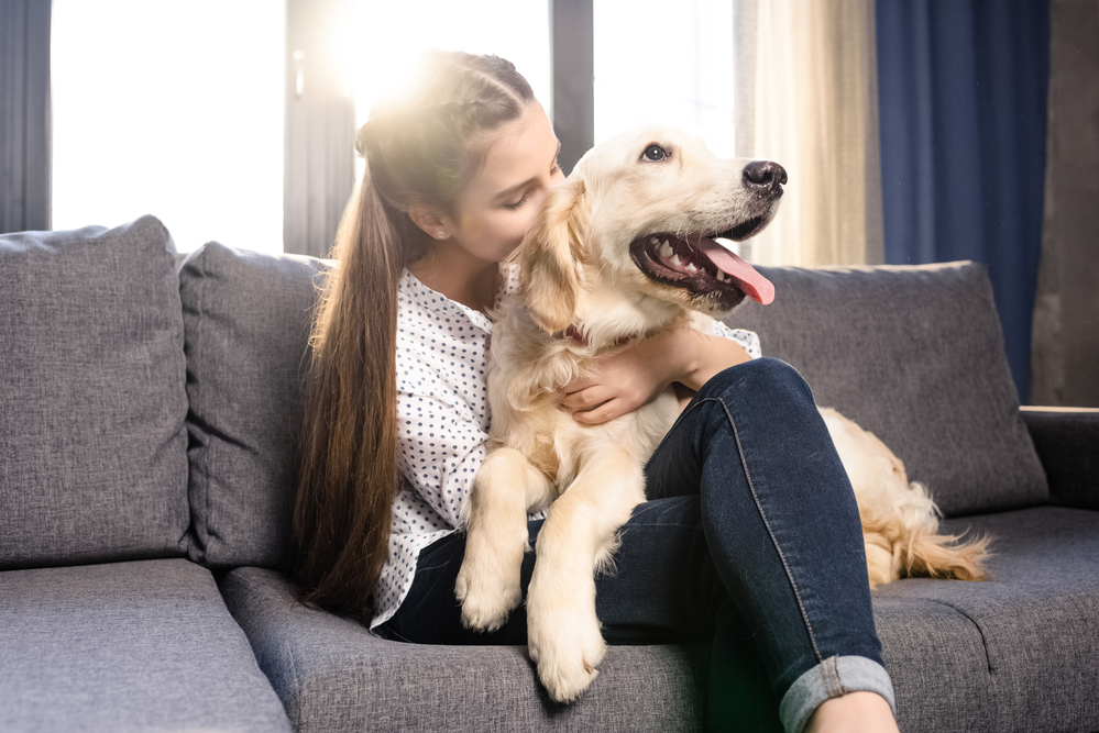 Photo of a young woman hugging her labrador